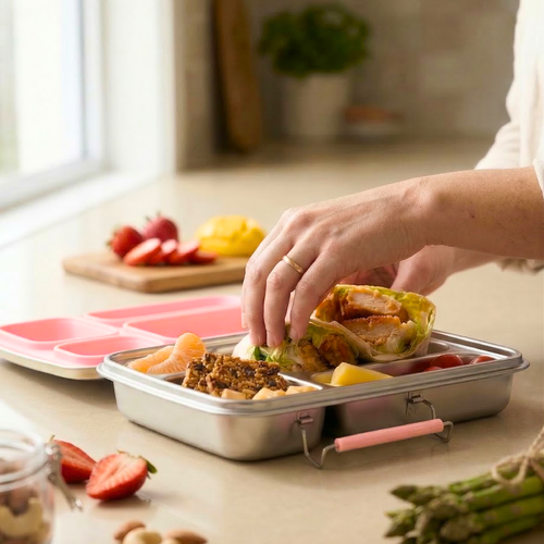 Mom packing a kids stainless steel bento lunch box with bubble gum pink lid, healthy school meal prep using nom quad