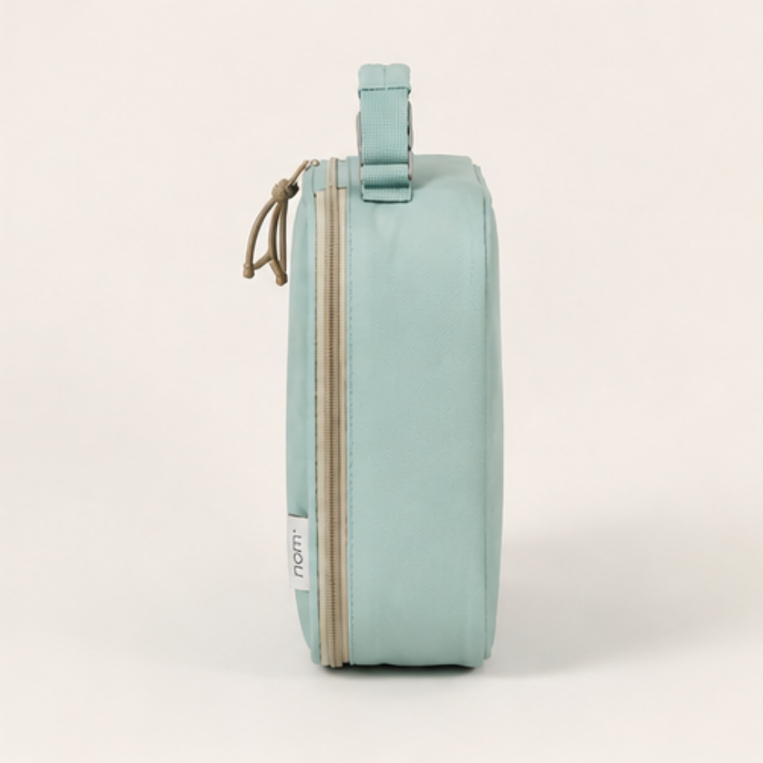 Side profile of Nom insulated lunch bag in mint green highlighting slim design and insulation
