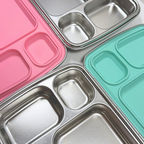 Close-up detail of stainless steel bento lunch box compartments with mint green and bubble gum pink silicone lids, nom quad